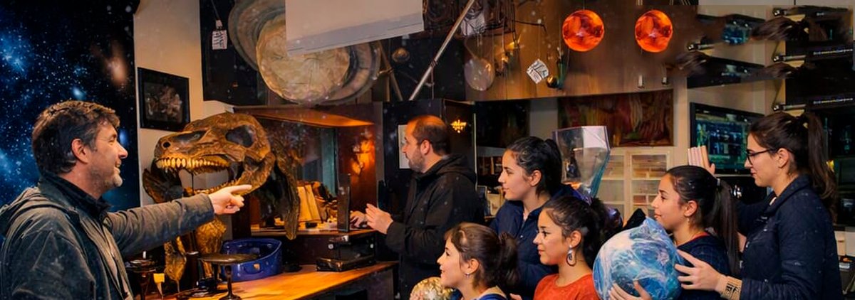 Guía mostrando piezas de la exposición a una familia en el Planetario CIASIVE